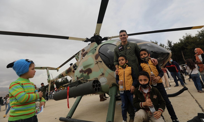 People pose for photos in front of a helicopter during an open day at Rayak Air Base in Bekaa, Lebanon, on Oct. 31, 2021. (Photo: Xinhua)
