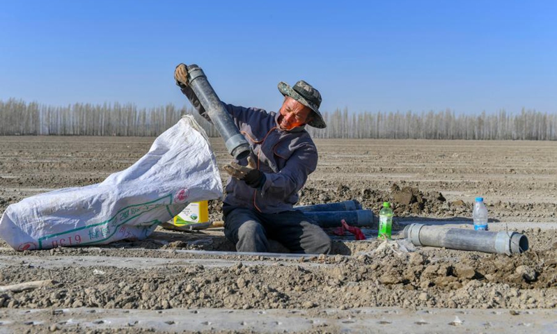 Lu Gaolin cleans a pipe for irrigation and fertilization at his field in Shawan City, northwest China's Xinjiang Uygur Autonomous Region, April 15, 2021.(Photo: Xinhua)
