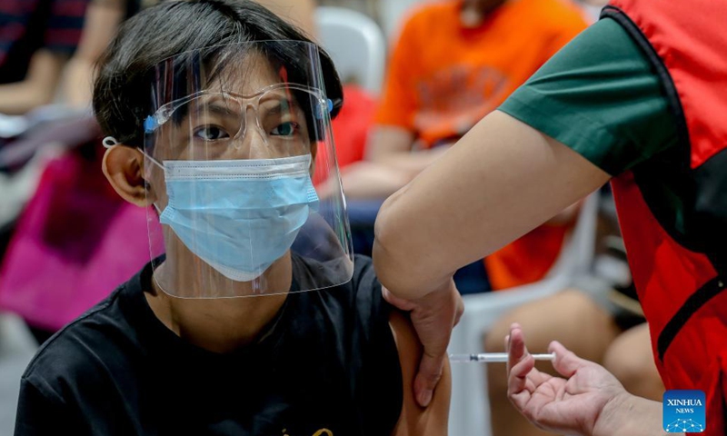 A boy is inoculated with a COVID-19 vaccine at a vaccination site in San Juan City, the Philippines on Nov. 3, 2021. The Philippine government has initiated its national COVID-19 immunization program to children aged 12 to 17 on Wednesday. (Photo: Xinhua)