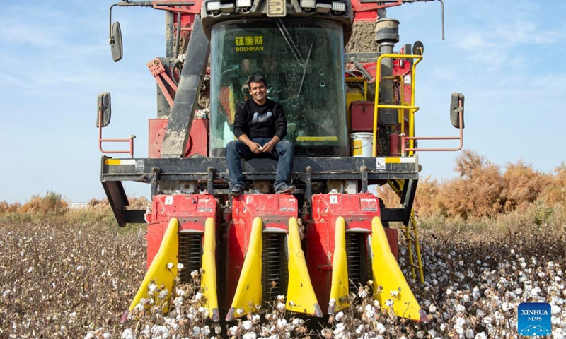 Amar Aziz poses on his cotton picker in a cotton field in Toyboldi Town of Xayar County, Aksu Prefecture, northwest China's Xinjiang Uygur Autonomous Region, Oct. 27, 2021. Amar Aziz lives in Xayar County, Aksu Prefecture, which is an important cotton-producing area in Xinjiang.(Photo: Xinhua)