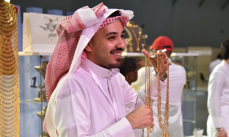 An exhibitor introduces golden necklaces at the Unique Jewelry Exhibition in Riyadh, Saudi Arabia, Nov. 3, 2021. (Photo: Xinhua)