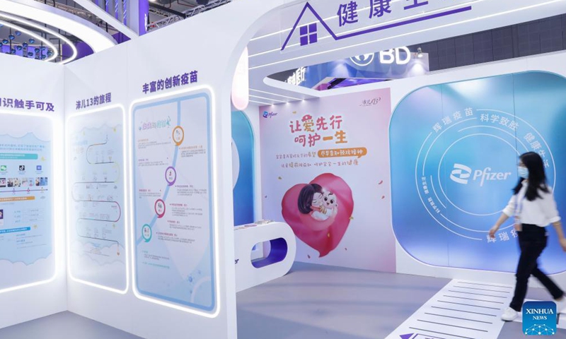 A woman walks past a booth showing Pfizer vaccines at the Medical Equipment and Healthcare Products Exhibition Area of the 4th China International Import Expo (CIIE) in east China's Shanghai, Nov. 6, 2021.Photo:Xinhua
