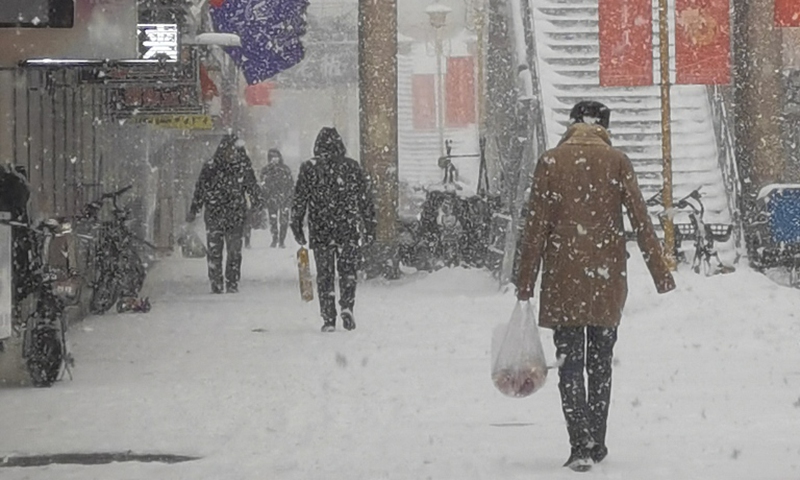 People walk in the snow in Tongliao, North China's Inner Mongolia Autonomous Region,on November 8, 2021. Photo: VCG