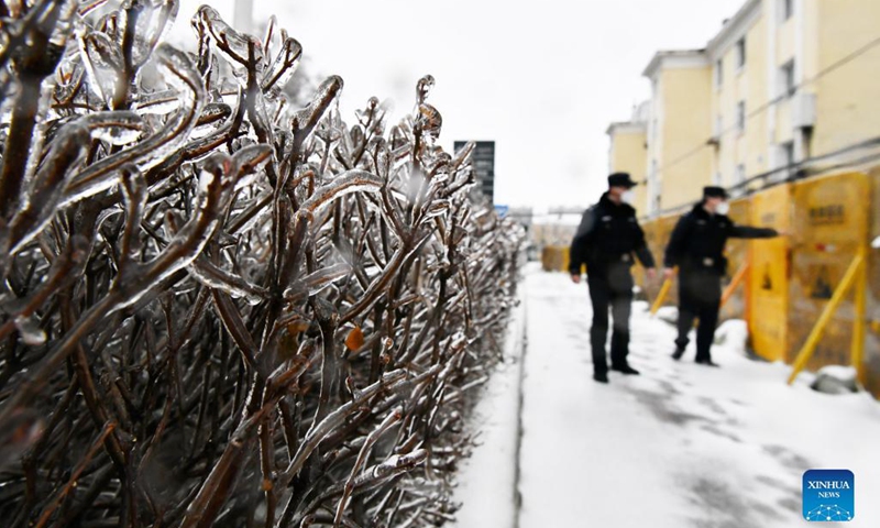 Police officers check the enclosure of a closed community in Pingfang District, Harbin, northeast China's Heilongjiang Province, Nov. 8, 2021. Despite the low temperature in Harbin, those who work outdoors are braving the cold wind, rain and snow to secure the COVID-19 epidemic prevention and control.(Photo: Xinhua)