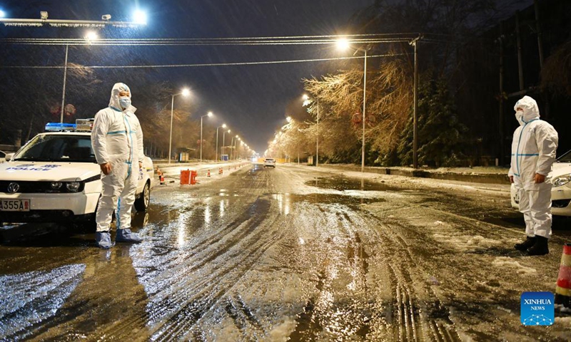 Police officers stand guard in freezing rain in Pingfang District, Harbin, northeast China's Heilongjiang Province, Nov. 8, 2021. Despite the low temperature in Harbin, those who work outdoors are braving the cold wind, rain and snow to secure the COVID-19 epidemic prevention and control.(Photo: Xinhua)