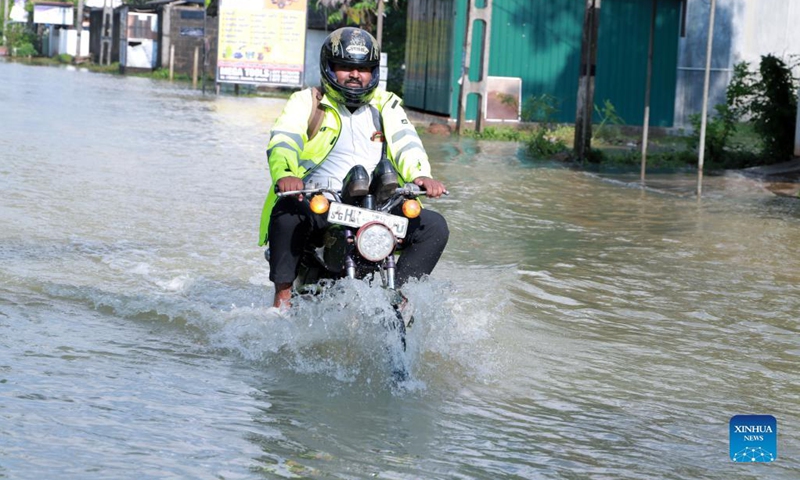 A man rides a motorcycle through a flooded road in Kochchikade, a town in Negombo, Sri Lanka, on Nov. 10, 2021. The death toll from heavy rains lashing Sri Lanka rose to 11, while 7,000 people have been affected, the Disaster Management Center said on Tuesday. (Photo: Xinhua)