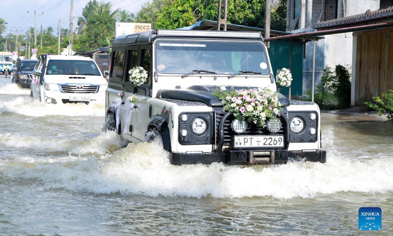 Vehicles move through a flooded road in Kochchikade, a town in Negombo, Sri Lanka, on Nov. 10, 2021. The death toll from heavy rains lashing Sri Lanka rose to 11, while 7,000 people have been affected, the Disaster Management Center said on Tuesday.(Photo: Xinhua)