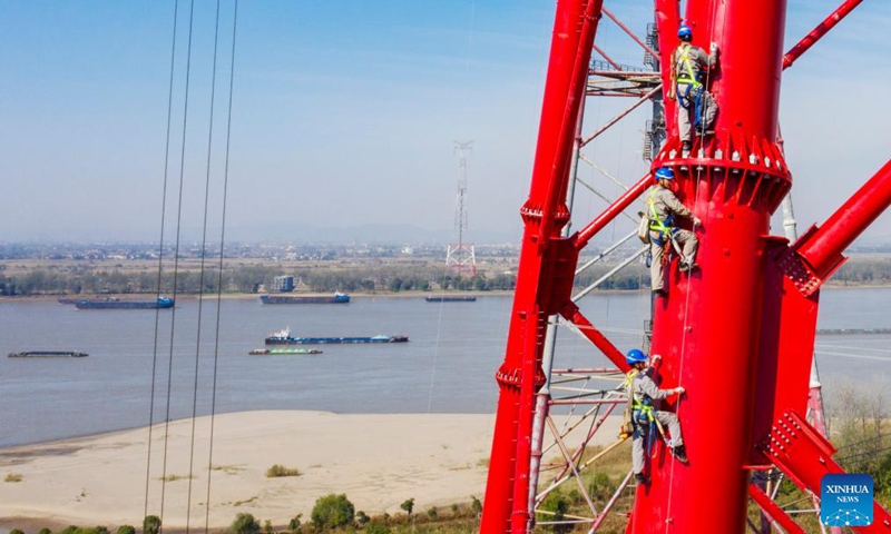 Aerial photo taken on Nov. 11, 2021 shows workers climbing a power transmission tower by the Yangtze River in Wuhu, east China's Anhui Province. Photo:Xinhua