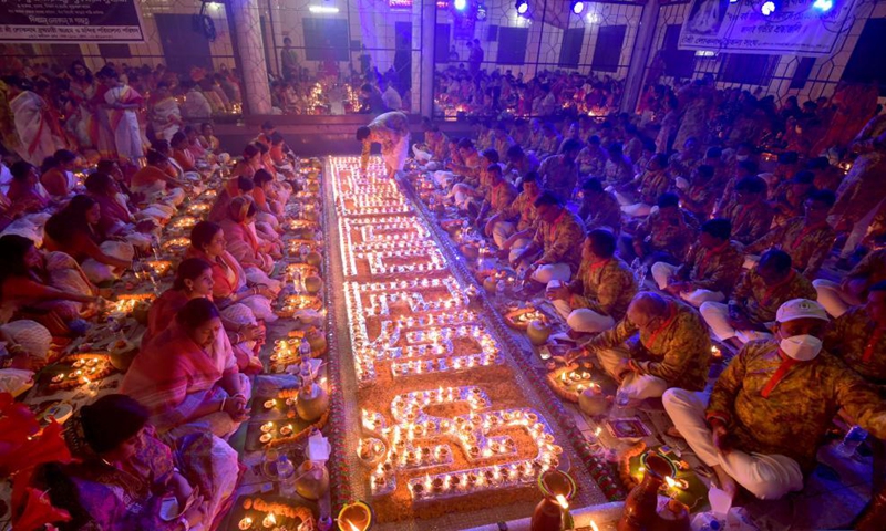 Hindu devotees sit for prayer with burning incense and oil lamps during the Rakher Upobash, a religious fasting festival, at a temple in Dhaka, Bangladesh, on Nov. 13, 2021.Photo:Xinhua