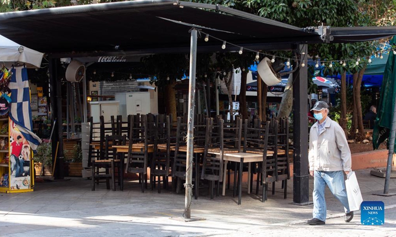 A man walks past a closed restaurant in Athens, Greece, on Nov. 16, 2021. Restaurants and cafes across Greece remained closed on Tuesday while a demonstration was held in Athens demanding further state support under the new COVID-19 restrictions introduced by the government this autumn to tackle the latest surge in infection rates.  (Xinhua)