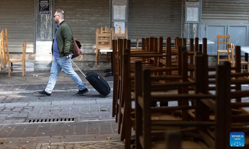A man walks past a closed restaurant in Athens, Greece, on Nov. 16, 2021. Restaurants and cafes across Greece remained closed on Tuesday while a demonstration was held in Athens demanding further state support under the new COVID-19 restrictions introduced by the government this autumn to tackle the latest surge in infection rates. (Xinhua)
