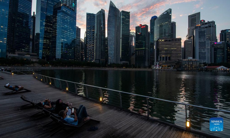 People enjoy the twilight view at Singapore's Marina Bay on Nov. 16, 2021. (Photo by Then Chih Wey/Xinhua) 