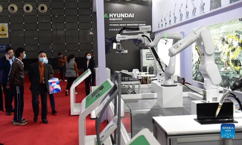 People look at smart industrial robots on display at the fourth World Manufacturing Convention in Hefei, east China's Anhui Province, Nov. 19, 2021. The fourth World Manufacturing Convention kicked off Friday in Hefei, capital of east China's Anhui Province. The four-day event, themed innovation-driven, digitally empowered: global manufacturing industry aligned for high-quality growth, aims to promote high-quality manufacturing and deepen exchanges between China and the rest of the world. (Xinhua/Huang Bohan)
