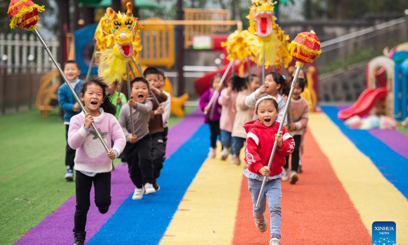 Children practice dragon dance at a kindergarten in Yaotianping Town in Dingcheng District of Changde, central China's Hunan Province, Nov. 17, 2021. The kindergarten invited folk artists to give a dragon dance and lion dance lesson to the children, providing small kids an opportunity to have a close watch on the local intangible cultural heritage. (Xinhua)
