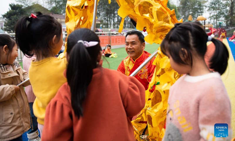 Children learn dragon dance from a folk artist at a kindergarten in Yaotianping Town in Dingcheng District of Changde, central China's Hunan Province, Nov. 17, 2021. The kindergarten invited folk artists to give a dragon dance and lion dance lesson to the children, providing small kids an opportunity to have a close watch on the local intangible cultural heritage. (Xinhua)