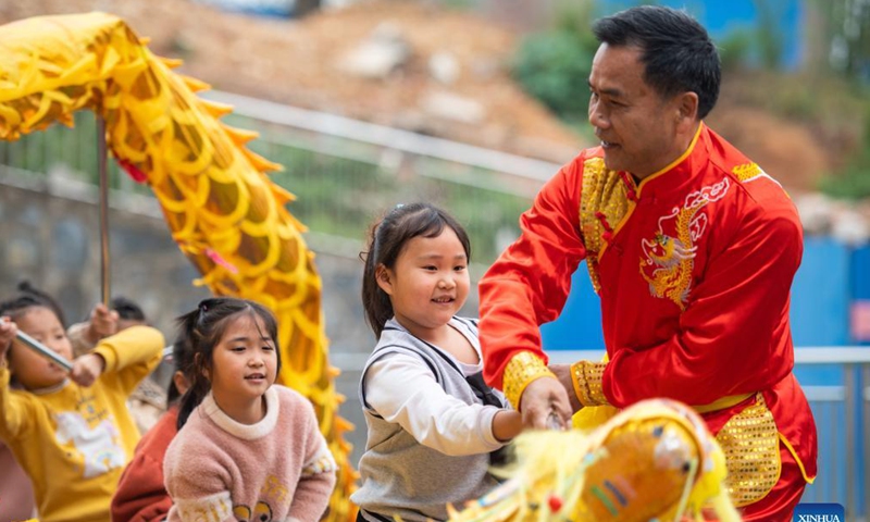 Children learn dragon dance from a folk artist at a kindergarten in Yaotianping Town in Dingcheng District of Changde, central China's Hunan Province, Nov. 17, 2021. The kindergarten invited folk artists to give a dragon dance and lion dance lesson to the children, providing small kids an opportunity to have a close watch on the local intangible cultural heritage.  (Xinhua)