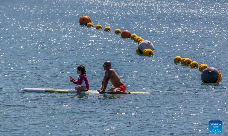 Tourists are seen on a paddleboard in Batangas Province, the Philippines on Nov 18, 2021.Photo:Xinhua