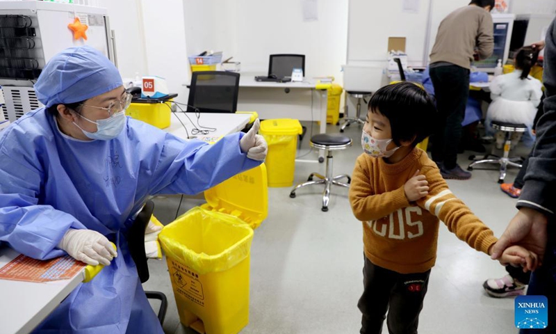 A medical worker gives thumb up to a child at a vaccination site in Xuhui District of Shanghai, east China, Nov. 20, 2021.Photo:Xinhua