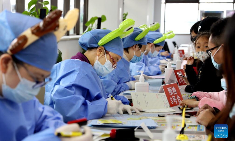 Medical workers wearing cartoon head decorations work at a vaccination site in Xuhui District of Shanghai, east China, Nov. 20, 2021.Photo:Xinhua