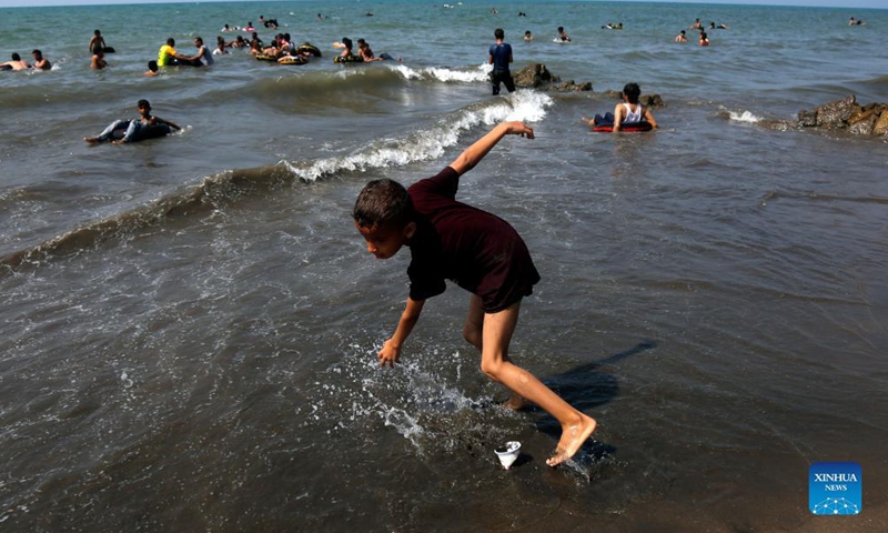 People enjoy themselves on the beach in Hodeidah, Yemen, Nov. 19, 2021. (Photo by Mohammed Mohammed/Xinhua) 