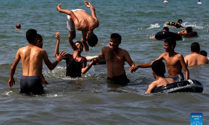People enjoy themselves on the beach in Hodeidah, Yemen, Nov. 19, 2021. (Photo by Mohammed Mohammed/Xinhua) 