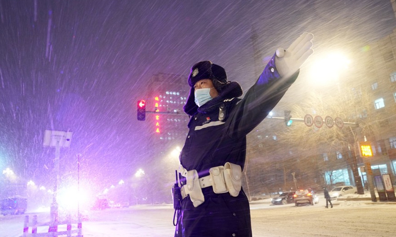 A police officer directs traffic in the snow in Harbin City, northeast China's Heilongjiang Province, Nov. 22, 2021.Photo:Xinhua