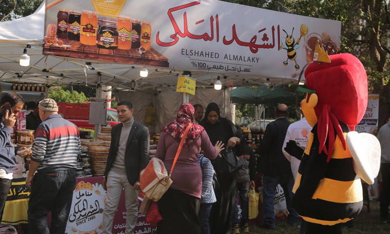 People visit a honey booth during the 3rd Egyptian Honey Festival in Giza, Egypt, Nov. 24, 2021.(Photo: Xinhua)