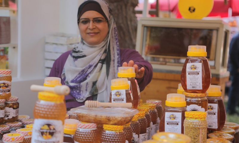 A honey vendor displays her products during the 3rd Egyptian Honey Festival in Giza, Egypt, Nov. 24, 2021.(Photo: Xinhua)