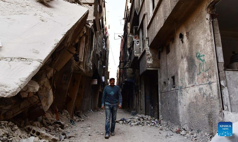 Jamal Saadi, a Palestinian refugee, walks at the Yarmouk Camp in the south of Damascus, Syria, on Nov. 17, 2021.Photo:Xinhua