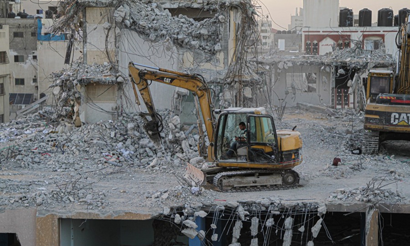 Bulldozers remove the rubble of the al-Jawhara Tower severely damaged by Israeli airstrikes during the May conflict, in Gaza City, on Nov. 28, 2021.(Photo: Xinhua)