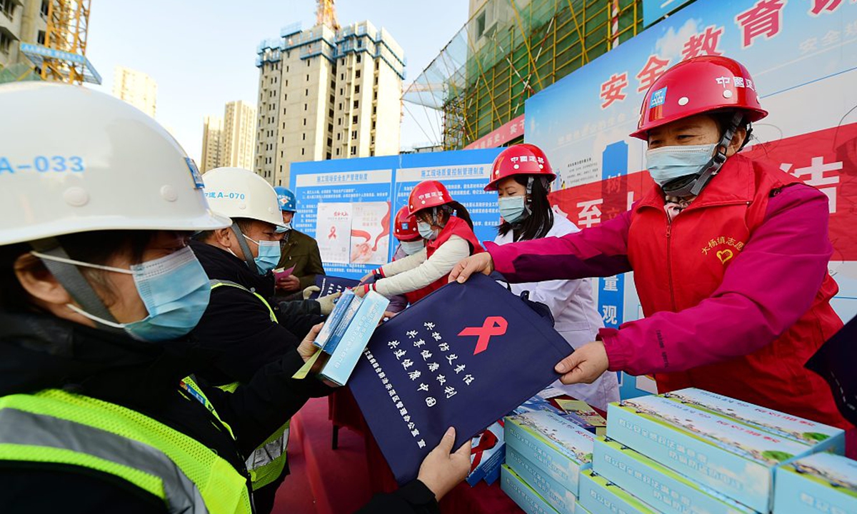 Volunteers hand out materials on HIV prevention at a construction site in Hefei, East China’s Anhui Province on November 30, 2021. Photo: VCG 