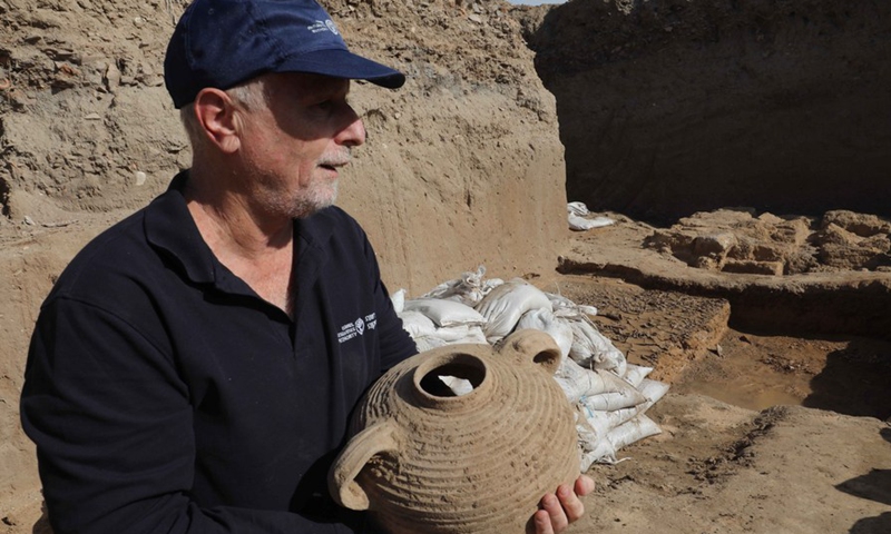 An archaeologist of Israel Antiquities Authority shows a pottery at an excavation site in the central Israeli city of Yavne on Nov. 29, 2021. (Photo: Xinhua)