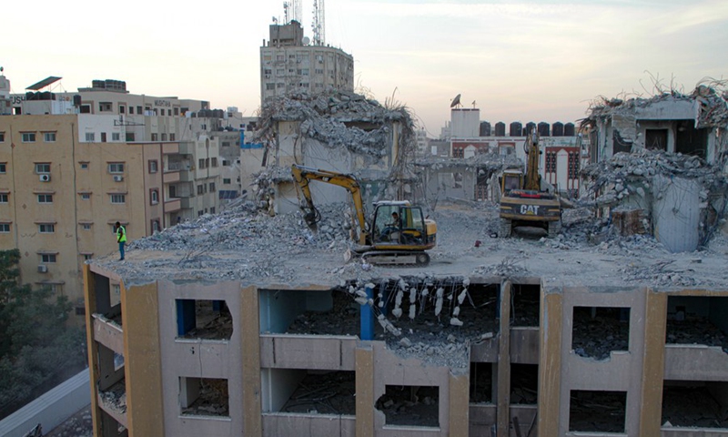 Bulldozers remove the rubble of the al-Jawhara Tower severely damaged by Israeli airstrikes during the May conflict, in Gaza City, on Nov. 28, 2021.(Photo: Xinhua)