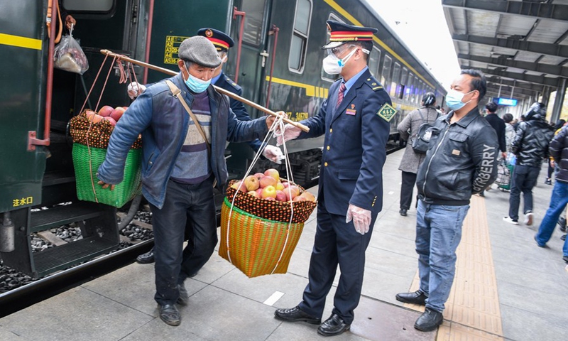 A villager shouldering apples for sale arrives at Caohai Station in southwest China's Guizhou Province, Nov. 30, 2021.(Photo: Xinhua)