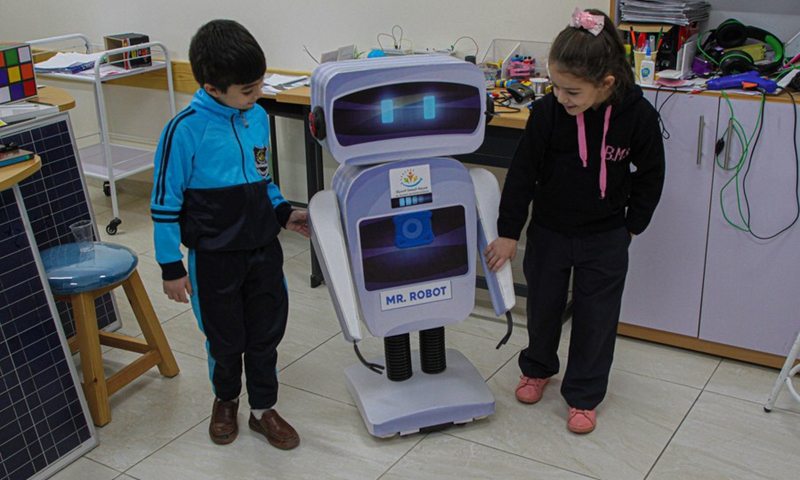 Palestinian students react with an interactive robot, at al-Basma school in Gaza City, on Nov. 28, 2021.(Photo: Xinhua)