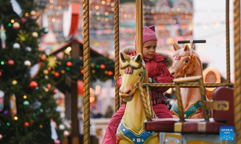 A girl enjoys a carousel at a Christmas fair in Red Square in Moscow, Russia, on Dec. 3, 2021.Photo:Xinhua