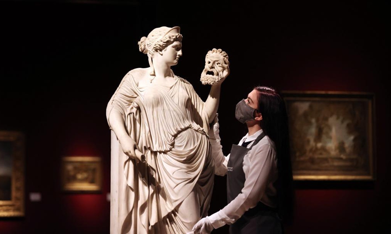 A staff member arranges an artwork for auction during a media preview of the Christie's London Classic Week auction in London, Britain, Dec. 3, 2021. Christie's London Classic Week presents art from antiquity to the 21st century, spanning five live auctions and four online-only sales.Photo:Xinhua