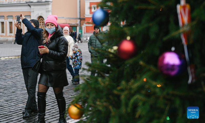 A woman wearing a face mask walks past a decorated Christmas tree in Red Square in Moscow, Russia, on Dec. 3, 2021. Photo:Xinhua