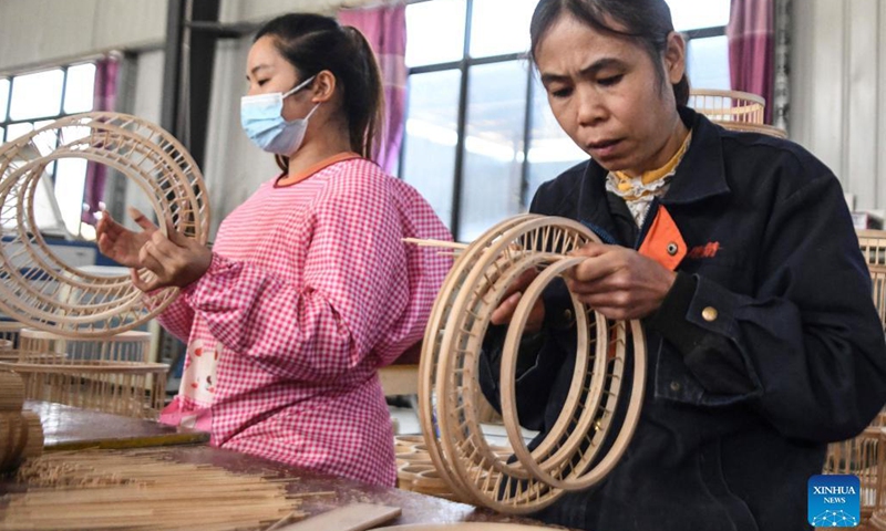 Workers make handicrafts at a handicrafts factory in Rong'an County, south China's Guangxi Zhuang Autonomous Region, Dec. 6, 2021. In recent years, Suixi County in south China's Guangdong Province, together with Rong'an County, take advantage of raw materials including rattan, bamboo and wood in Rong'an and process them into handicrafts for garden. These products are exported to more than 40 countries and regions.(Photo: Xinhua)