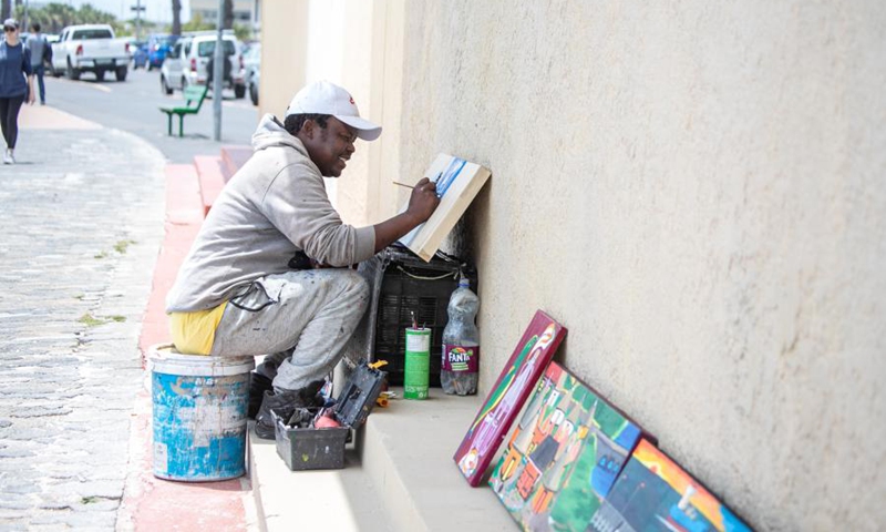 A person paints on the seaside in Cape Town, South Africa, Dec. 5, 2021.(Photo: Xinhua)