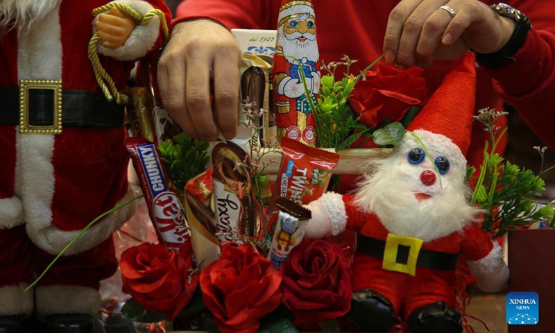 A Palestinian seller works on decorations at a store for the upcoming Christmas holiday in Gaza City, on Dec. 6, 2021.(Photo: Xinhua)