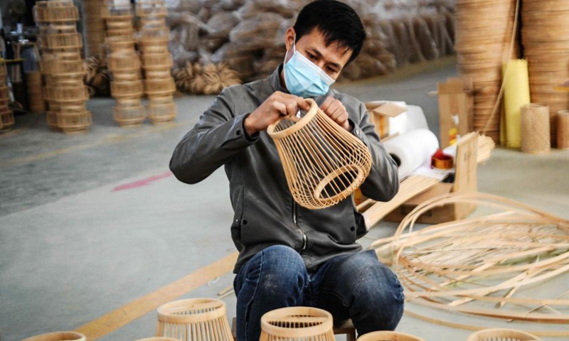 A worker checks a handicraft at a handicrafts factory in Rong'an County, south China's Guangxi Zhuang Autonomous Region, Dec. 6, 2021. In recent years, Suixi County in south China's Guangdong Province, together with Rong'an County, take advantage of raw materials including rattan, bamboo and wood in Rong'an and process them into handicrafts for garden. These products are exported to more than 40 countries and regions.(Photo: Xinhua)