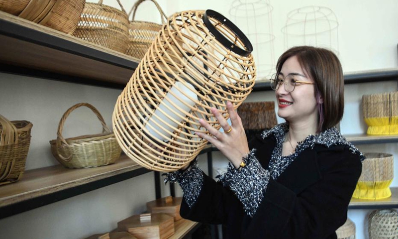 A staff member arranges handicrafts at a handicrafts factory in Rong'an County, south China's Guangxi Zhuang Autonomous Region, Dec. 6, 2021. In recent years, Suixi County in south China's Guangdong Province, together with Rong'an County, take advantage of raw materials including rattan, bamboo and wood in Rong'an and process them into handicrafts for garden. These products are exported to more than 40 countries and regions.(Photo: Xinhua)
