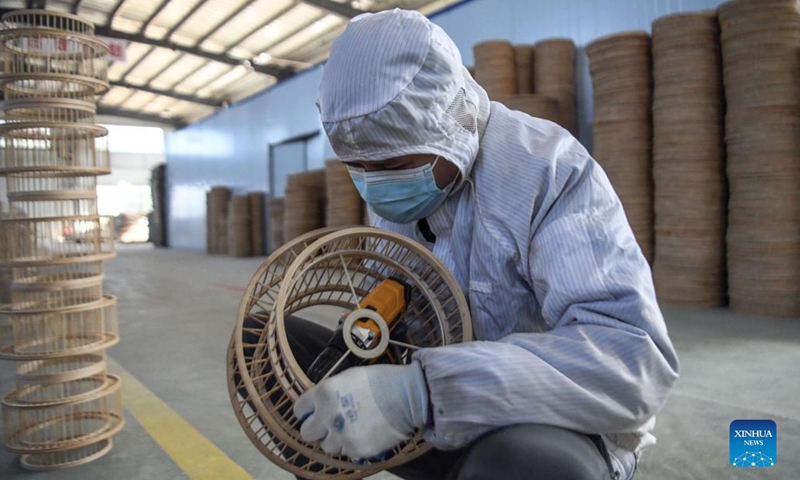 A worker makes a handicraft at a handicrafts factory in Rong'an County, south China's Guangxi Zhuang Autonomous Region, Dec. 6, 2021. In recent years, Suixi County in south China's Guangdong Province, together with Rong'an County, take advantage of raw materials including rattan, bamboo and wood in Rong'an and process them into handicrafts for garden. These products are exported to more than 40 countries and regions.(Photo: Xinhua)