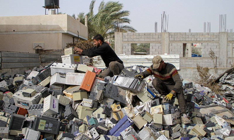 Workers collect damaged batteries at a shop in the southern Gaza Strip city of Khan Younis, on Dec. 8, 2021.(Photo: Xinhua)