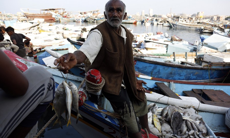 A man sells fish at a fishing port in Hodeidah, Yemen, November 19, 2021. (Photo: Xinhua)