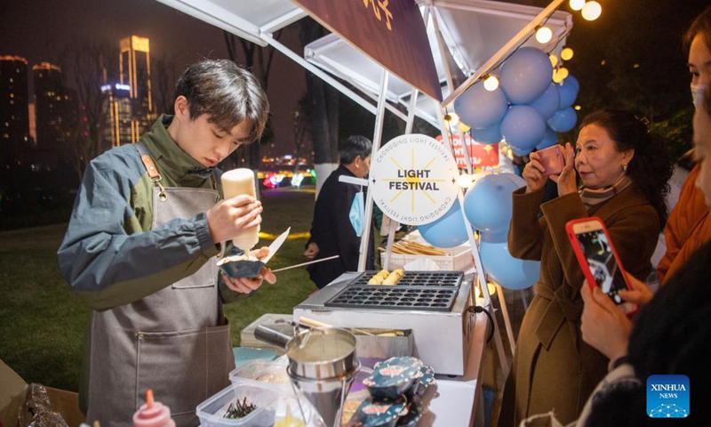 Tourists buy snacks at a night market in southwest China's Chongqing Municipality, Dec. 8, 2021.Photo:Xinhua