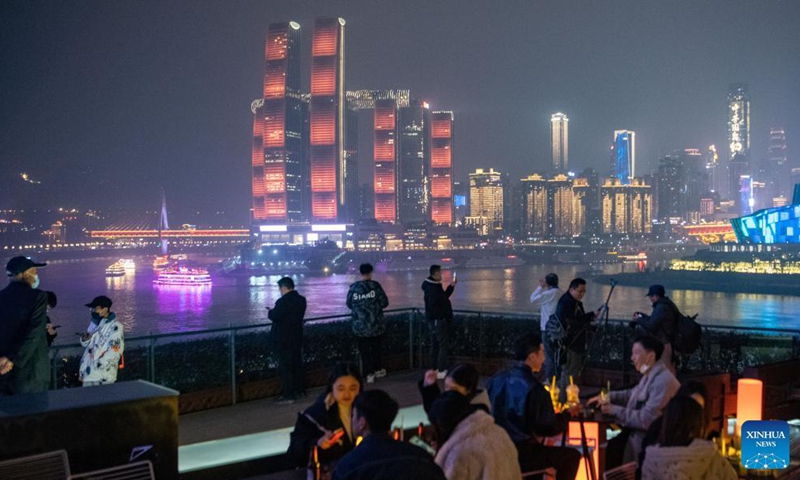 People enjoy the night view at a bar in southwest China's Chongqing Municipality, Dec. 8, 2021.Photo:Xinhua
