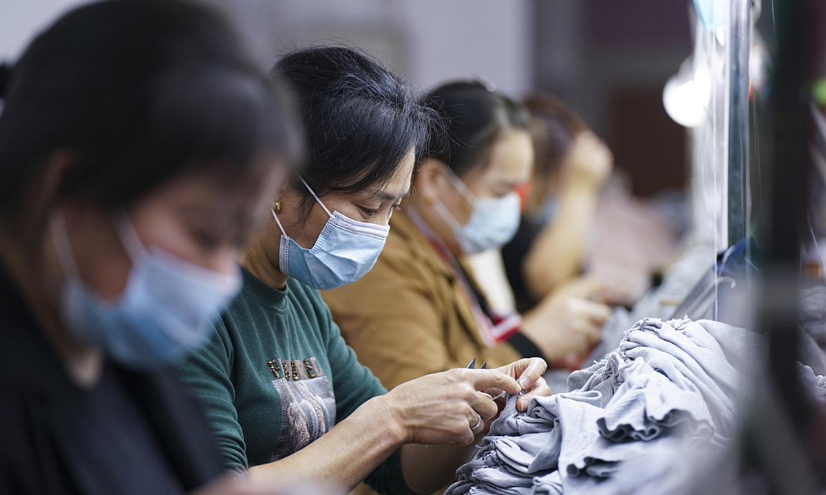 Workers work in a clothing manufacturing firm in Xinyu, Jiangxi Province on November 5, 2021. Photo: VCG