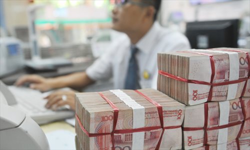 A bank staff member handles yuan transaction in Qionghai, South China's Hainan Province on Tuesday.  Photo: CFP